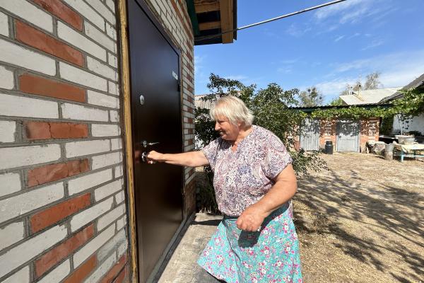 Paraskoviia putting the key in the new front door of the renovated house.